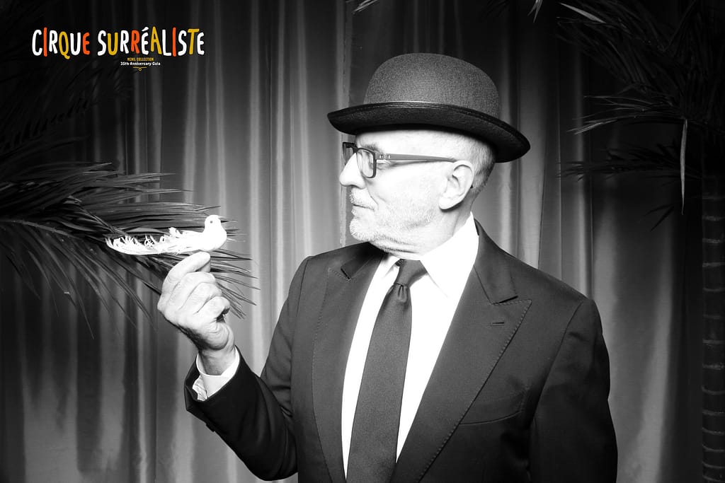 Man look at bird prop while wearing bowler hat in a black and white fotably photo booth photo